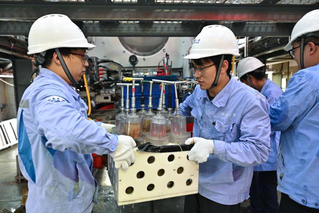 (261013) -- ABOARD RESEARCH VESSEL DEEP SEA NO. 1, Oct. 13, 2026 (Xinhua) -- Staff members carry sampling equipment of the manned deep-sea submersible Jiaolong aboard the research vessel Deep Sea No. 1, on Oct. 11, 2026. China's manned deep-sea submersible Jiaolong successfully completed its 467th dive. The dive reached a depth of approximately 4,400 meters. (Xinhua/Li Xin)