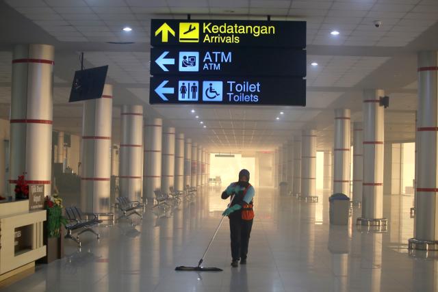 (261013) -- PALANGKA RAYA, Oct. 13, 2026 (Xinhua) -- A staff member works at an empty airport amid thick haze caused by forest and peatland fires in Palangka Raya, Central Kalimantan, Indonesia, Oct. 13, 2026. (Photo by Regina Safri/Xinhua)