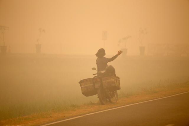 (261013) -- PALANGKA RAYA, Oct. 13, 2026 (Xinhua) -- A person takes photos amid thick haze caused by forest and peatland fires in Palangka Raya, Central Kalimantan, Indonesia, Oct. 13, 2026. (Photo by Regina Safri/Xinhua)