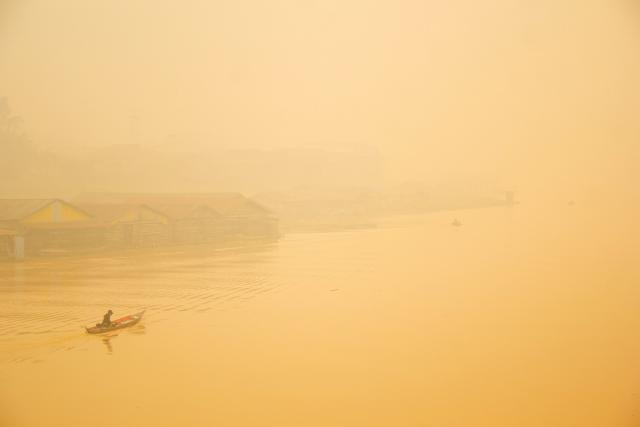 (261013) -- PALANGKA RAYA, Oct. 13, 2026 (Xinhua) -- A man takes a boat amid thick haze caused by forest and peatland fires in Palangka Raya, Central Kalimantan, Indonesia, Oct. 12, 2026. (Photo by Dirga Gendes/Xinhua)
