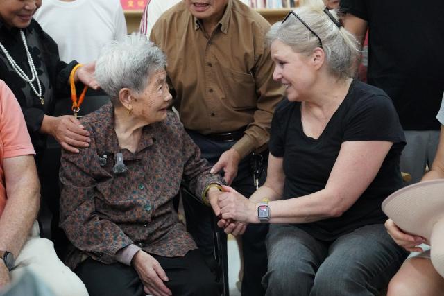 (261013) -- NANCHANG, Oct. 13, 2026 (Xinhua) -- A descendant of a rescued Doolittle Raid participant holds the hand of Guan Dongxiang in Shangrao, east China's Jiangxi Province, Oct. 11, 2026. (Xinhua/Zhou Mi)