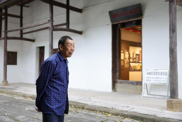 (261014) -- XISHUI, Oct. 14, 2026 (Xinhua) -- Song Guangping, son of late Red Army soldier Song Jiatong, is pictured in front of his former house in Lintan Village, Xishui County, southwest China's Guizhou Province, Sept. 10, 2026. The Chishui River winds through the mountains, with its waters murmuring as they flow past Lintan Village in Xishui County of southwest China's Guizhou Province.
   Beside the former site of a Party Branch set by the Red Army in Lintan Village, a leafy pomelo tree stands quietly. Locals call it the "Red Army Pomelo."
   For 77-year-old Song Guangping, the tree carries a lifelong memory. Standing before the tree near his old home, he often recalls the afternoon when his father, Song Jiatong, brought back the pomelo seedlings. To him, it is more than a tree. It is a living link between the Long March, the deep bond between the Red Army and the people, and a village's journey from poverty to revitalization.
   Song Jiatong arrived in Guizhou with the Central Red Army during the Long March, the historic military maneuver in modern Chinese history. He was seriously wounded during the Four Crossings of the Chishui River and was rescued by local villagers.
   After recovering, he chose to stay in Lintan, where he married and raised a family. In the early 1980s, Song Jiatong returned to his hometown of Ningdu, east China's Jiangxi Province, and brought back several honey pomelo seedlings. Four were planted, but only one survived.
   No one has imagined that the single surviving seedling would take root by the Chishui River, bloom, and bear fruit, or that through villagers' grafting, it would eventually grow into more than 300 mu (20 hectares) of pomelo groves along the river valley.
   "My father always kept the people in his heart," Song Guangping said. "Bringing the pomelo seedlings to Lintan was his way of helping the villagers live a better life."
   Because the tree embodies the memory of unity between the Red Army soldiers and the people, locals affectionately call it the "Red Army Pomelo."
   It soon became the village's "fruit of prosperity." From the 1980s into the early 2000s, more than 100 households in Lintan grew the fruit. At that time, they were the only pomelo growers for miles around. One pomelo sold for 5 yuan (about 0.75 U.S. dollars), and a single tree could produce two or three hundred fruits, earning a family several thousand yuan.
   The income helped cover school fees for children across the village. Over the years, more than 100 students from Lintan went on to college.
   The influence of the "Red Army Pomelo" has spread beyond Lintan. Villagers in Qinggangpo Village of Xishui County also transplanted and grafted trees from the original pomelo, introduced more varieties, and established a pomelo industry demonstration base.
   "Qinggangpo Village is known for the Battle of Qinggangpo during the Long March," said Yi Song, Party secretary of the village. "We receive 200,000 visitors a year, and the tourism has been boosting our fruit farming. Since we began developing the pomelo industry, we have planted 1,800 mu (120 hectares) of honey pomelo, and total output is expected to reach 1.2 million yuan (about 180,000 U.S. dollars) this year."
   From a single pomelo seedling to the industry of pomelo planting, the red legacy has never left this land. It has simply taken on a new form that is rooted in the soil and bringing sweetness to everyday life. (Xinhua/Wang Jingqiang)