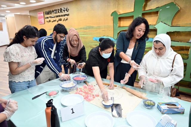 (261014) -- HAWALLI GOVERNORATE, Oct. 14, 2026 (Xinhua) -- People participate in a Chinese culinary experience event in Hawalli Governorate, Kuwait, Oct. 13, 2026. Titled "The Taste of China: Jiaozi (Dumpling) Experience," the event was organized by the China Cultural Center in Kuwait to introduce traditional Chinese food culture to local residents. More than 100 people participated in the event. (Photo by Asad/Xinhua)