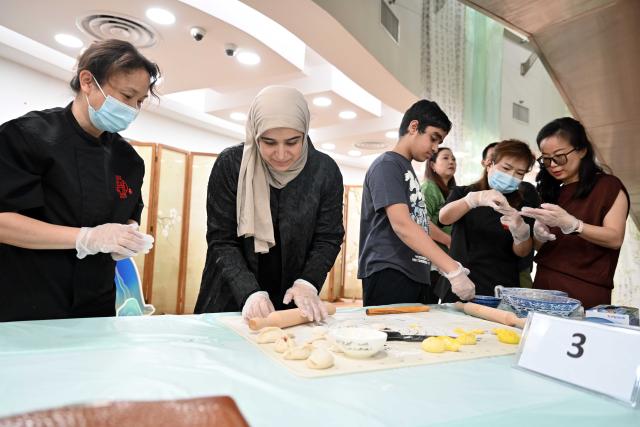 (261014) -- HAWALLI GOVERNORATE, Oct. 14, 2026 (Xinhua) -- People participate in a Chinese culinary experience event in Hawalli Governorate, Kuwait, Oct. 13, 2026. Titled "The Taste of China: Jiaozi (Dumpling) Experience," the event was organized by the China Cultural Center in Kuwait to introduce traditional Chinese food culture to local residents. More than 100 people participated in the event. (Photo by Asad/Xinhua)