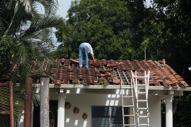 (261014) -- PANAMA CITY, Oct. 14, 2026 (Xinhua) -- A resident repairs his house after an earthquake in Macaracas, Los Santos, Panama, Oct. 13, 2026. (Photo by Daniel Gonzalez/Xinhua)