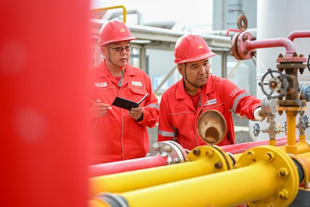 (261014) -- BEIJING, Oct. 14, 2026 (Xinhua) -- Staff members inspect a pilot facility for carbon dioxide miscible-phase flooding of Xinjiang Oilfield Company of China National Petroleum Corporation (CNPC) in Karamay, northwest China's Xinjiang Uygur Autonomous Region, Sept. 1, 2026. (Xinhua/Ding Lei)