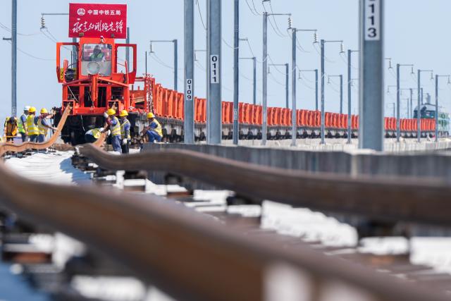 (261014) -- NANJING, Oct. 14, 2026 (Xinhua) -- This photo taken on Oct. 14, 2026 shows constructors laying tracks on the Nantong-Ningbo high-speed railway in east China's Jiangsu Province. A high-speed railway linking Nantong of east China's Jiangsu Province with Ningbo of east China's Zhejiang Province started its track laying on Wednesday. The project is an important part of the coastal channel of China's high-speed rail network, which features eight north-south vertical lines and eight east-west horizontal lines. The new line will promote the high-quality integrated development of the Yangtze River Delta after its completion. (Xinhua/Li Bo)