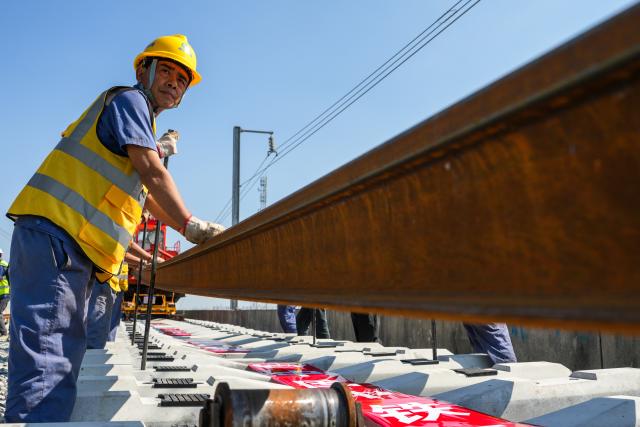(261014) -- NANJING, Oct. 14, 2026 (Xinhua) -- This photo taken on Oct. 14, 2026 shows constructors laying tracks on the Nantong-Ningbo high-speed railway in east China's Jiangsu Province. A high-speed railway linking Nantong of east China's Jiangsu Province with Ningbo of east China's Zhejiang Province started its track laying on Wednesday. The project is an important part of the coastal channel of China's high-speed rail network, which features eight north-south vertical lines and eight east-west horizontal lines. The new line will promote the high-quality integrated development of the Yangtze River Delta after its completion. (Xinhua/Li Bo)
