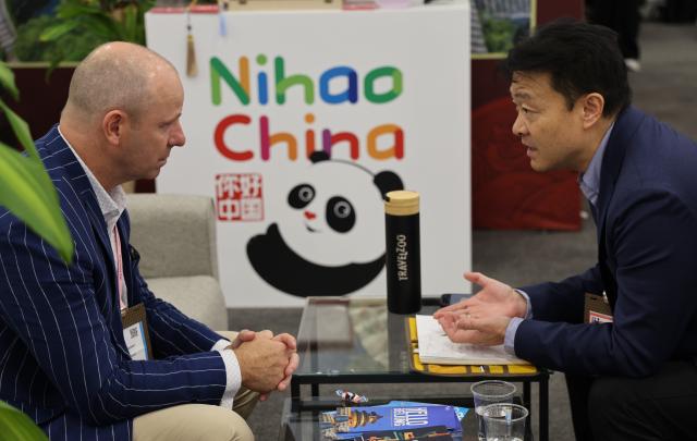 (261014) -- LAS VEGAS, Oct. 14, 2026 (Xinhua) -- A man (L) visits the Chinese pavilion during IMEX America 2026 at the Mandalay Bay Convention Center in Las Vegas, Nevada, the United States, Oct. 13, 2026.
  China showcased its tourism offerings at IMEX America 2026, which opened here on Tuesday.
  The three-day trade show brought together tourism officials and industry representatives from several Chinese provinces and regions under the national tourism brand "Nihao! China." (Photo by Zeng Hui/Xinhua)