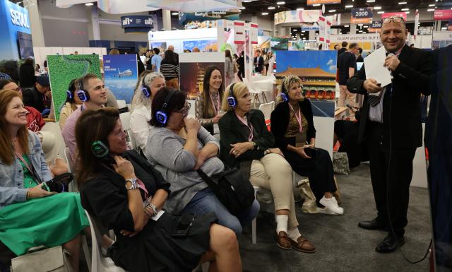 (261014) -- LAS VEGAS, Oct. 14, 2026 (Xinhua) -- People listen to an introduction at the Chinese pavilion during IMEX America 2026 at the Mandalay Bay Convention Center in Las Vegas, Nevada, the United States, Oct. 13, 2026.
  China showcased its tourism offerings at IMEX America 2026, which opened here on Tuesday.
  The three-day trade show brought together tourism officials and industry representatives from several Chinese provinces and regions under the national tourism brand "Nihao! China." (Photo by Zeng Hui/Xinhua)