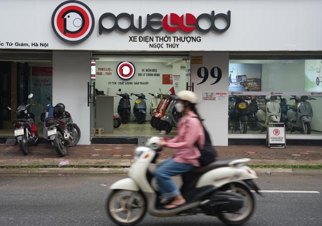(261014) -- HANOI, Oct. 14, 2026 (Xinhua) -- A woman rides an electric motorcycle past an Aima store in Hanoi, capital of Vietnam, Aug. 21, 2026.
  Chinese electric motorcycle brands are becoming an increasingly common sight on the streets of Vietnam's major cities, as the country accelerates its shift toward greener urban transport.
  More Vietnamese residents have turned to electric motorcycles, with Chinese brands emerging as popular choices thanks to their competitive prices, diverse models and growing presence in the Vietnamese market. (Xinhua/Liu Ying)