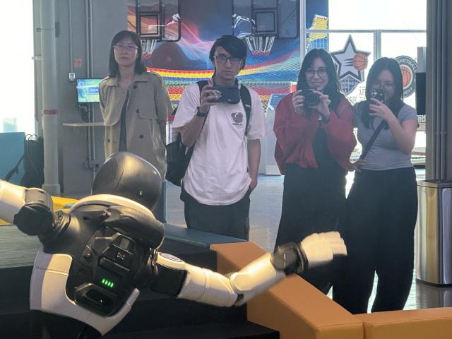 (261015) -- BEIJING, Oct. 15, 2026 (Xinhua) -- A university student from Ecuador (2nd R) and her friends shoot videos of a humanoid robot performance at Robot Mall in Beijing, capital of China, Oct. 2, 2026. TO GO WITH "Feature: Global tourists flock to China to see AI-powered future" (Xinhua/Wang Meiqi)