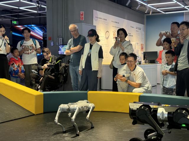 (261015) -- BEIJING, Oct. 15, 2026 (Xinhua) -- Tourists watch a robot dog performance at Robot Mall in Beijing, capital of China, Oct. 2, 2026. TO GO WITH "Feature: Global tourists flock to China to see AI-powered future" (Xinhua/Wang Meiqi)