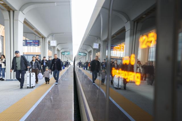 (261015) -- HARBIN, Oct. 15, 2026 (Xinhua) -- Passengers walk on a train platform at Yichun West Railway Station in Yichun, northeast China's Heilongjiang Province, Oct. 14, 2026.
  The Harbin-Yichun high-speed railway, China's northernmost high-speed railway running through a region of discontinuous permafrost in northeast China's Heilongjiang Province, officially entered service on Sept. 28. With a designed speed of 250 kilometers per hour, the 318-km line slashed travel time between Harbin and Yichun from about seven hours to just two hours.
   The efficient and convenient rail service is expected to facilitate the free flow of talents, passengers, materials and technologies, boosting coordinated regional development in Heilongjiang and forming a key corridor for the region's high-quality development. (Xinhua/Wang Song)