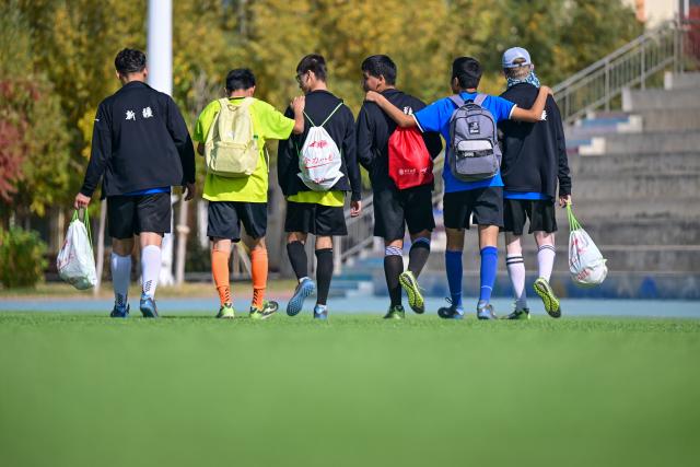 (261015) -- URUMQI, Oct. 15, 2026 (Xinhua) -- Players leave the pitch after training at Xinjiang Special Education Vocational Secondary School in Changji Hui Autonomous Prefecture, northwest China's Xinjiang Uygur Autonomous Region, Oct. 14, 2026. Xinjiang's first blind football team is known as the 'Wei Wei Wei' team. It takes its name from the call players shout to locate teammates and avoid collisions. This call is the communication code of this special sport.
In blind football, players wear light-blocking blindfolds throughout the match. They track the ball by the bell inside it and keep calling 'wei, wei, wei' to gauge teammates' positions, enabling them to dribble, pass and shoot without sight. In training, they run, collide, feel the boundary boards, and build muscle memory through countless falls and getting back up. For visually impaired teenagers who rarely dare to sprint at full speed in daily life, this enclosed pitch is a place where they can run freely.
'We cannot see the world, but we strive to make the world see us.' In the darkness, guided by their calls and the sound of the ball, these young athletes break through barriers and shine brightly on the green pitch. (Xinhua/Ding Lei)