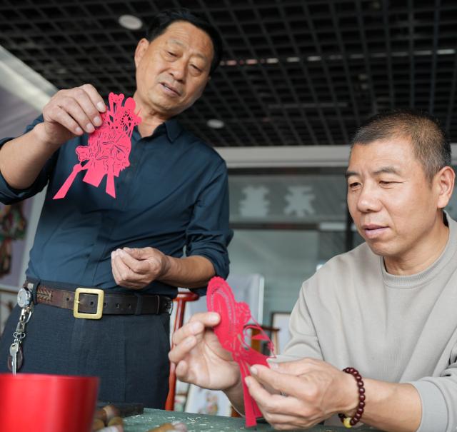 (261015) -- SHENYANG, Oct. 15, 2026 (Xinhua) -- Xu Zilin (L) discusses with his brother on the making of shadow puppets in Lingyuan City, northeast China's Liaoning Province, Oct. 10, 2026.
  Lingyuan shadow puppetry, a national-level intangible cultural heritage in China, comes vividly alive amid dazzling light and shadow. Movements of the puppets embody the local folk traditions, which have been passed down through generations.
  Xu Zilin was born in 1964 to a family that has the Lingyuan shadow puppetry as its walk of life for ages. More than 40 years of professional experience made Xu a representative inheritor of the craft and an influential figure in the trade. Many of his vocal passages have been modeled for teaching.
  To better promote shadow plays, Xu founded a shadow puppetry troupe and brought quality productions to the grassroots level. Over the years, Xu and his troupe have performed more than 4,000 shows in Liaoning and neighboring provinces. (Xinhua/Li Gang)
