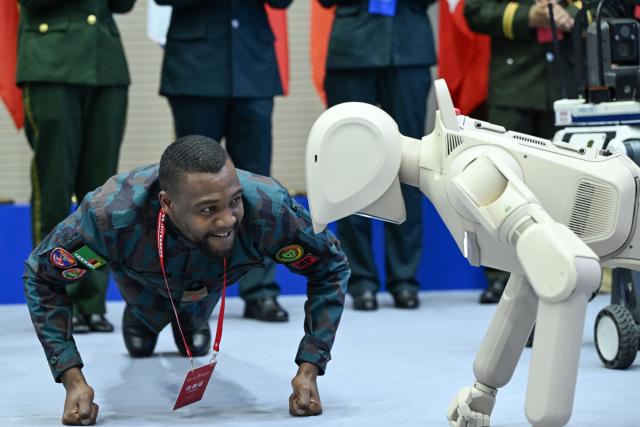 (261015) -- BEIJING, Oct. 15, 2026 (Xinhua) -- A participant interacts with a robot during the Great Wall-2026 International Forum on Counter-Terrorism in Beijing, capital of China, Oct. 14, 2026. The Great Wall-2026 International Forum on Counter-Terrorism concluded here on Thursday. (Photo by Yue Chang/Xinhua)