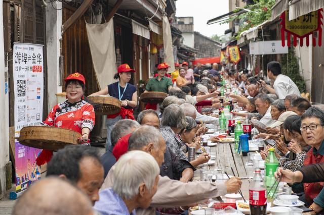 (261015) -- LANXI, Oct. 15, 2026 (Xinhua) -- Elderly people attend a long-table banquet in Yanggang Village of Lanxi, east China's Zhejiang Province, Oct. 15, 2026. Funded by kind-hearted people, the banquet held on Thursday was attended by more than 500 people aged 60 and above to mark the upcoming Double Ninth Festival. Celebrated on the ninth day of the ninth lunar month, it is an occasion to care for and send blessings to older people in China. (Photo by Hu Xiaofei/Xinhua)