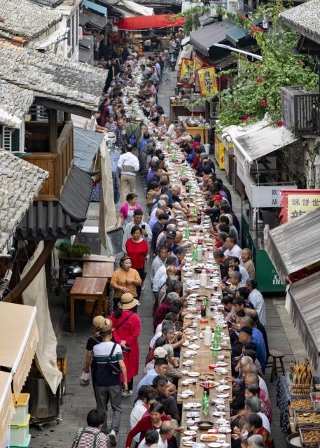 (261015) -- LANXI, Oct. 15, 2026 (Xinhua) -- An aerial drone photo taken on Oct. 15, 2026 shows a view of a long-table banquet held for the elderly in Yanggang Village of Lanxi, east China's Zhejiang Province. Funded by kind-hearted people, the banquet held on Thursday was attended by more than 500 people aged 60 and above to mark the upcoming Double Ninth Festival. Celebrated on the ninth day of the ninth lunar month, it is an occasion to care for and send blessings to older people in China. (Photo by Hu Xiaofei/Xinhua)