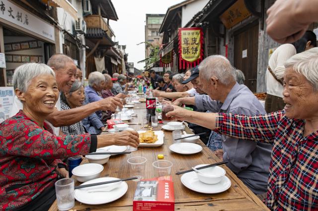 (261015) -- LANXI, Oct. 15, 2026 (Xinhua) -- Elderly people attend a long-table banquet in Yanggang Village of Lanxi, east China's Zhejiang Province, Oct. 15, 2026. Funded by kind-hearted people, the banquet held on Thursday was attended by more than 500 people aged 60 and above to mark the upcoming Double Ninth Festival. Celebrated on the ninth day of the ninth lunar month, it is an occasion to care for and send blessings to older people in China. (Photo by Hu Xiaofei/Xinhua)
