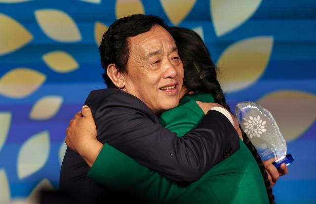 (261015) -- ROME, Oct. 15, 2026 (Xinhua) -- Yin Yuzhen (R) hugs Director-General of the Food and Agriculture Organization of the United Nations (FAO) Qu Dongyu during a ceremony for FAO's 100 Women Heroes in Agrifood Systems and Rural Development, in Rome, Italy, Oct. 15, 2026. Chinese sand-control pioneer Yin Yuzhen has been named among the FAO's 100 Women Heroes in Agrifood Systems and Rural Development, a global recognition initiative launched by the FAO.
  Yin has spent more than four decades combating desertification in the Maowusu Sandy Land in north China's Inner Mongolia Autonomous Region. After decades of persistent tree planting, she and her family have transformed stretches of the once-barren landscape into a green expanse, overcoming harsh conditions and shifting sands.
  Her story also forged an enduring friendship with retired U.S. teacher Ronald Sakolsky, who raised 5,000 U.S. dollars decades ago to support her afforestation work. (Xinhua/Wang Kaiyan)
