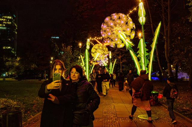(261015) -- WARSAW, Oct. 15, 2026 (Xinhua) -- People take selfie in a light garden in Swietokrzyski Park in Warsaw, Poland, Oct. 15, 2026. The year-round light garden opened on Thursday, featuring illuminated plant and butterfly installations and interactive projections that respond to visitors' movements. (Photo by Jaap Arriens/Xinhua)