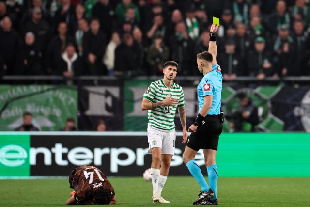 (261016) -- BUDAPEST, Oct. 16, 2026 (Xinhua) -- Referee Damian Sylwestrzak (R) gives Attila Osvath (C) of Ferencvaros a yellow card during the UEFA Europa League 2026/27 League Phase match between Ferencvaros and Viktoria Plzen in Budapest, Hungary, Oct. 15, 2026. (Xinhua/Hu Zhixuan)