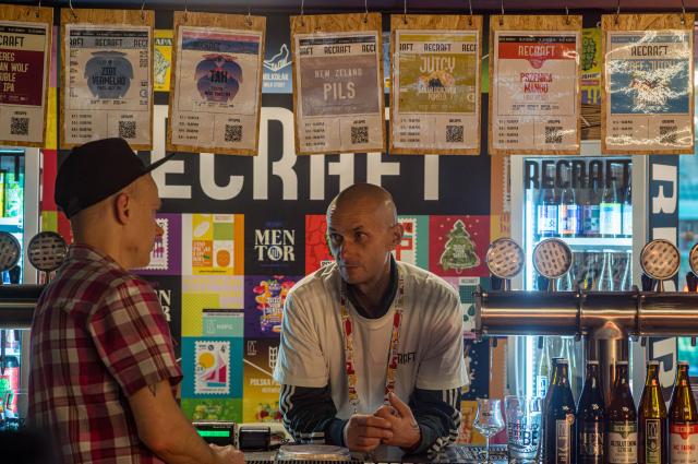 (261016) -- WARSAW, Oct. 16, 2026 (Xinhua) -- A visitor and a staff member talk at the 22nd Warsaw Beer Festival in Warsaw, Poland, Oct. 15, 2026. The festival runs from Oct. 15 to 17 at Legia Warsaw Stadium, featuring beer tastings, food trucks, workshops and live music. Launched in 2014, the festival is held every spring and autumn. (Photo by Jaap Arriens/Xinhua)