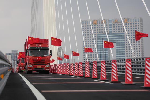 (261016) -- BEIJING, Oct. 16, 2026 (Xinhua) -- This photo taken on Oct. 15, 2026 shows trucks running on the new China-DPRK Yalu River bridge. The new China-DPRK Yalu River bridge officially opened to traffic on Thursday, with both sides jointly holding an opening ceremony on this cross-border artery. (Xinhua/Pan Yulong)
