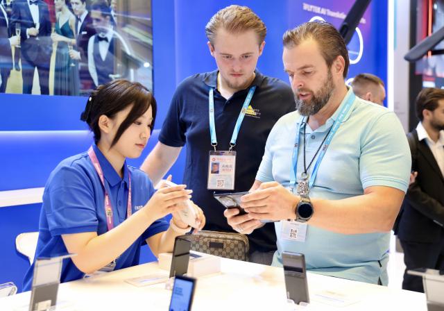 (261016) -- GUANGZHOU, Oct. 16, 2026 (Xinhua) -- Overseas buyers learn about a translation device during the Canton Fair in Guangzhou, south China's Guangdong Province, Oct. 15, 2026. The 140th edition of the China Import and Export Fair, also known as the Canton Fair, opened to visitors in Guangzhou, capital of south China's Guangdong Province on Thursday, with more than 30,000 exhibiting companies and about 340,000 overseas buyers expected to attend.
  Serving as a barometer and wind vane of China's foreign trade, this year's fair, marking its 70th anniversary, features innovation, intelligence, greater specialization and higher quality.
  The Canton Fair is one of the world's few one-stop trade platforms offering a complete range of products with convenience and efficiency, while bringing together the latest products and technologies. (Xinhua/Lu Hanxin)