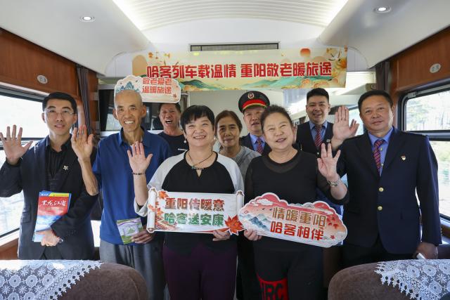(261016) -- HARBIN, Oct. 16, 2026 (Xinhua) -- Passengers pose for a group photo with crew members aboard the train Z114, on Oct. 16, 2026.
  The train Z114 service from Harbin West Railway Station to Haikou in south China's Hainan Province has witnessed a surging passenger loads since early October when temperatures started to drop in Heilongjiang Province.
   Covering about 4,300 kilometers in 47 hours and 50 minutes, the train is a popular choice among elderly travelers from northeast China heading south to escape the bitter winter cold.
   The China Railway Harbin Group provides elderly-friendly services and additional assistance for passengers with special needs to make their journeys more comfortable. (Xinhua/Wang Song)
