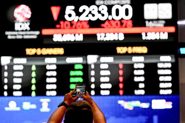 (261016) -- JAKARTA, Oct. 16, 2026 (Xinhua) -- A man takes photos at the Indonesia Stock Exchange building in Jakarta, Indonesia, Oct. 16, 2026. Indonesia's benchmark stock index tumbled over 11 percent on Friday and the rupiah weakened sharply after global index provider MSCI announced a proposal to reclassify the market from "emerging" to "standalone" status. (Xinhua/Agung Kuncahya B.)