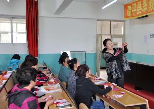 (261016) -- CHAOYANG, Oct. 16, 2026 (Xinhua) -- This undated file photo shows Yang Zhihong teaching paper-cutting techniques at a vocational school in Jianping County of Chaoyang City, northeast China's Liaoning Province. Known for its bold, rustic style and designs inspired by folk stories and traditional symbols, Jianping paper-cutting reflects the rich culture of western Liaoning Province.
   Born in 1972, Yang Zhihong is a representative inheritor of Jianping paper-cutting, a provincial-level intangible cultural heritage of Liaoning Province. Inspired by local folk artists from an early age, she has devoted herself to preserving this traditional art. 
   Over decades of practice, Yang has won several major industry awards. Today, she continues to explore the art's cultural heritage and create new works, keeping this ancient folk tradition alive. (Xinhua)