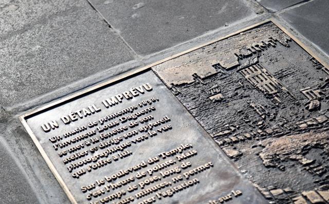 (261016) -- PARIS, Oct. 16, 2026 (Xinhua) -- This photo taken on Oct. 16, 2026 shows a plaque titled "An Unexpected Detail" in Paris, France. A bronze plaque titled "An Unexpected Detail" was unveiled at Place de la Republique in Paris on Thursday. It honors "Boulevard du Temple," an image taken in 1838 by French photography pioneer Louis Daguerre and believed to be the first photograph to show people. (Xinhua/Wu Huiwo)