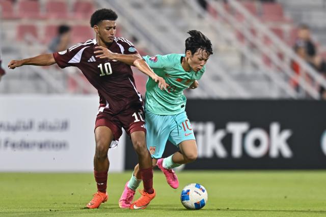 (261017) -- DOHA, Oct. 17, 2026 (Xinhua) -- Omar Ayman Mahmoud (L) of Qatar vies with Peng Xianchen of China during the Gulf Football Federation (GFF) Gulf Cup U-17 Qatar 2026 football match between Qatar and China at Grand Hamad Stadium in Doha, Qatar, Oct. 16, 2026. (Photo by Nikku/Xinhua)