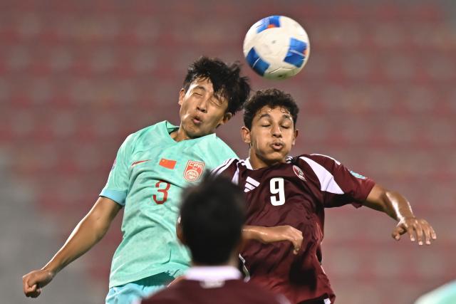 (261017) -- DOHA, Oct. 17, 2026 (Xinhua) -- Abdulla Shaheen Aldosari (R) of Qatar vies with Cheng Zixuan of China during the Gulf Football Federation (GFF) Gulf Cup U-17 Qatar 2026 football match between Qatar and China at Grand Hamad Stadium in Doha, Qatar, Oct. 16, 2026. (Photo by Nikku/Xinhua)