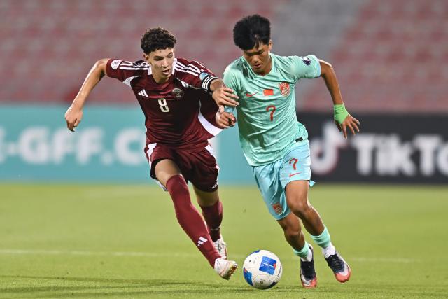 (261017) -- DOHA, Oct. 17, 2026 (Xinhua) -- Mohamed Hammoudi (L) of Qatar vies with Liu Kaiyuan of China during the Gulf Football Federation (GFF) Gulf Cup U-17 Qatar 2026 football match between Qatar and China at Grand Hamad Stadium in Doha, Qatar, Oct. 16, 2026. (Photo by Nikku/Xinhua)
