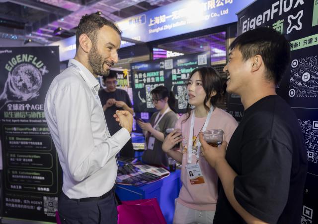 (261017) -- SHANGHAI, Oct. 17, 2026 (Xinhua) -- Hamza Boukili (L), founder of Shanghai Yunsuan Tech Company, talks to young entrepreneurs during the 2026 World AI Conference in Shanghai, east China, July 20, 2026. (Xinhua/Wang Xiang)