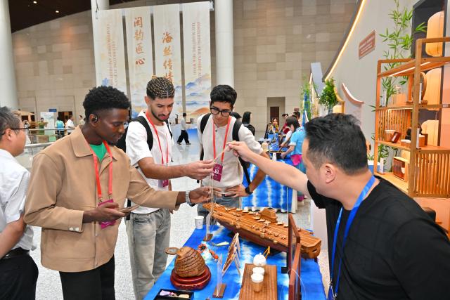 (261017) -- FUZHOU, Oct. 17, 2026 (Xinhua) -- Foreign youths attending the opening ceremony of the 21st Century Maritime Silk Road Local Government Cooperation and International Friendship Cities Dialogue visit a Fujian intangible cultural heritage exhibition in Fuzhou, southeast China's Fujian Province, Oct. 17, 2026. (Xinhua/Jiang Kehong)