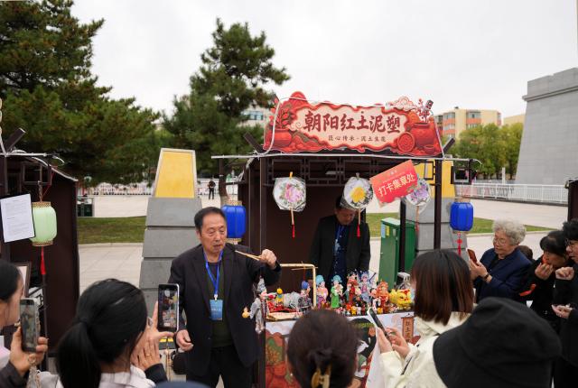 (261017) -- SHENYANG, Oct. 17, 2026 (Xinhua) -- Sun Yu'en displays his Chaoyang red clay figure work at a market for intangible cultural heritage in Chaoyang, northeast China's Liaoning Province, Oct. 16, 2026. Chaoyang red clay figure is a provincial-level intangible cultural heritage in Liaoning Province, northeast China. 
  Sun Yu'en, an inheritor of this craft, has loved the art since childhood. In 1998, he devoted himself to the craft and learned the core skills from his teacher. Sun's artworks emphasize the expressions and details of the figures, embodying rustic charm. He has also created a series of moving clay figures, which are popular among young people. (Xinhua/Li Gang)