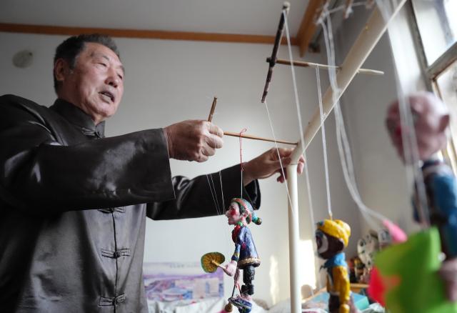 (261017) -- SHENYANG, Oct. 17, 2026 (Xinhua) -- Sun Yu'en displays Chaoyang red clay figure work at his studio in Chaoyang, northeast China's Liaoning Province, Oct. 10, 2026. Chaoyang red clay figure is a provincial-level intangible cultural heritage in Liaoning Province, northeast China. 
  Sun Yu'en, an inheritor of this craft, has loved the art since childhood. In 1998, he devoted himself to the craft and learned the core skills from his teacher. Sun's artworks emphasize the expressions and details of the figures, embodying rustic charm. He has also created a series of moving clay figures, which are popular among young people. (Xinhua/Li Gang)