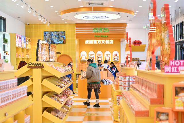 (261017) -- HARBIN, Oct. 17, 2026 (Xinhua) -- Tourists select tiger-themed cultural and creative products at a store in the Siberian Tiger Park in Harbin, northeast China's Heilongjiang Province, Oct. 16, 2026. The Hengdaohezi Siberian Tiger Park and the Siberian Tiger Park, both located in northeast China's Heilongjiang Province, have been collaborating to conserve Siberian tigers through rewilding training, conservation research and public engagement. (Xinhua/Sun Ruibo)