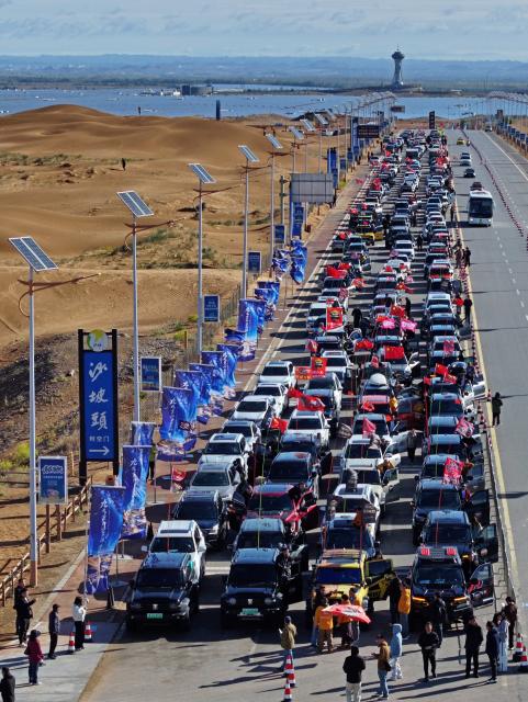 (261017) -- ZHONGWEI, Oct. 17, 2026 (Xinhua) -- An aerial drone photo taken on Oct. 17, 2026 shows vehicles gathering at the Shapotou scenic area in Zhongwei, northwest China's Ningxia Hui Autonomous Region. Marking the beginning of a desert self-driving event, a ceremony was held here on Saturday, gathering more than 500 vehicles for self-driving tours and over 1,000 tourists. (Xinhua/Wang Peng)