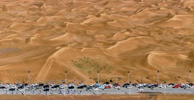 (261017) -- ZHONGWEI, Oct. 17, 2026 (Xinhua) -- An aerial drone photo taken on Oct. 17, 2026 shows vehicles driving at the Shapotou scenic area in Zhongwei, northwest China's Ningxia Hui Autonomous Region. Marking the beginning of a desert self-driving event, a ceremony was held here on Saturday, gathering more than 500 vehicles for self-driving tours and over 1,000 tourists. (Xinhua/Wang Peng)