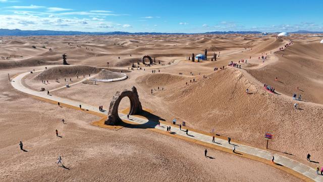 (261017) -- ZHONGWEI, Oct. 17, 2026 (Xinhua) -- An aerial drone photo taken on Oct. 17, 2026 shows tourists visiting the Tengger Desert in Zhongwei, northwest China's Ningxia Hui Autonomous Region. Marking the beginning of a desert self-driving event, a ceremony was held here on Saturday, gathering more than 500 vehicles for self-driving tours and over 1,000 tourists. (Xinhua/Wang Peng)