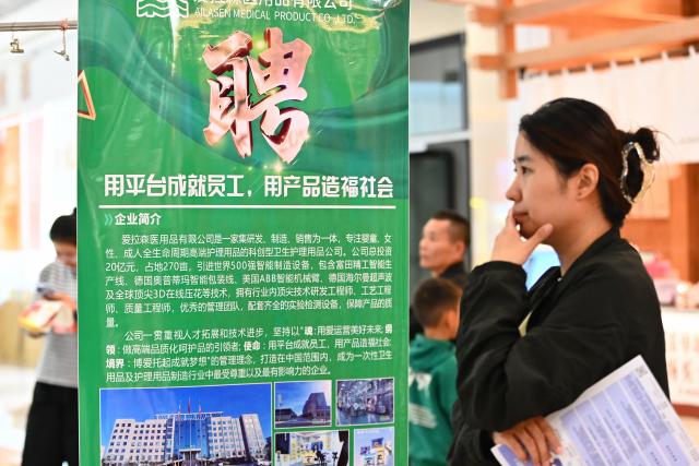 (261017) -- BEIJING, Oct. 17, 2026 (Xinhua) -- A jobseeker goes through job information at a job fair in Tengzhou, east China's Shandong Province, Oct. 17, 2026. Job fairs are held in various cities across China, connecting jobseekers with potential employers and creating opportunities for both. (Photo by Li Zhijun/Xinhua)