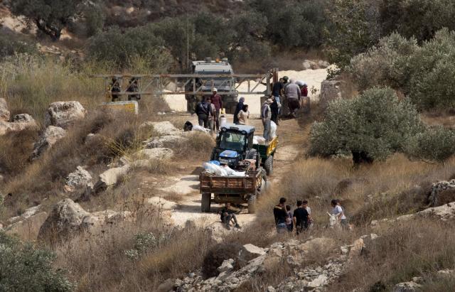(261017) -- NABLUS, Oct. 17, 2026 (Xinhua) -- Palestinian farmers are seen at an Israeli military checkpoint after the forces prevented them from harvesting olives at their lands, in the village of Salem, east of Nablus, in the West Bank, on Oct. 17, 2026. (Photo by Nidal Eshtayeh/Xinhua)