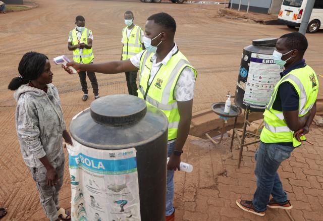 (261017) -- NAIROBI, Oct. 17, 2026 (Xinhua) -- Health officials monitor the body temperatures of a woman entering Kenya at One-Stop Border Post in Busia, Kenya, Oct. 16, 2026. Kenya's Ministry of Health on Saturday confirmed four new cases of Ebola Bundibugyo virus disease, bringing the total number of cases to seven, as efforts to prevent community transmission of the disease gathered pace. Kenya has stepped up Ebola screening and control measures at its border crossings. (Photo by John Okoyo/Xinhua)