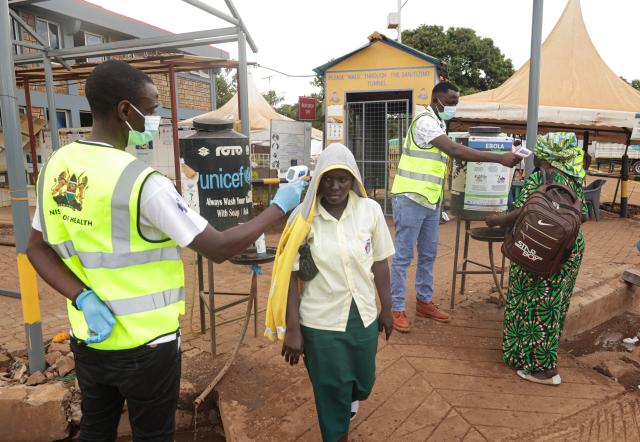 (261017) -- NAIROBI, Oct. 17, 2026 (Xinhua) -- Health officials monitor the body temperatures of people entering Kenya at the One-Stop Border Post in Busia, Kenya, Oct. 16, 2026. Kenya's Ministry of Health on Saturday confirmed four new cases of Ebola Bundibugyo virus disease, bringing the total number of cases to seven, as efforts to prevent community transmission of the disease gathered pace. Kenya has stepped up Ebola screening and control measures at its border crossings. (Photo by John Okoyo/Xinhua)
