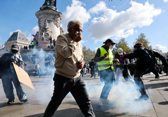 (261017) -- PARIS, Oct. 17, 2026 (Xinhua) -- People take cover from tear gas during a protest in Paris, France, Oct. 17, 2026. French Interior Minister Laurent Nunez said Saturday that about 550,000 people took part in the protests across France. According to French media reports, the demonstrations brought together farmers, climate activists, trade unions and students, expressing demands on fuel prices, the cost of living, education and public services. (Xinhua/Wu Huiwo)